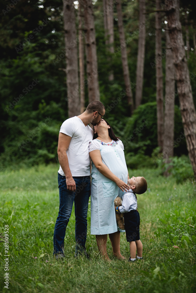 Pregnant young woman with her family in nature Pregnant young woman with her family in nature