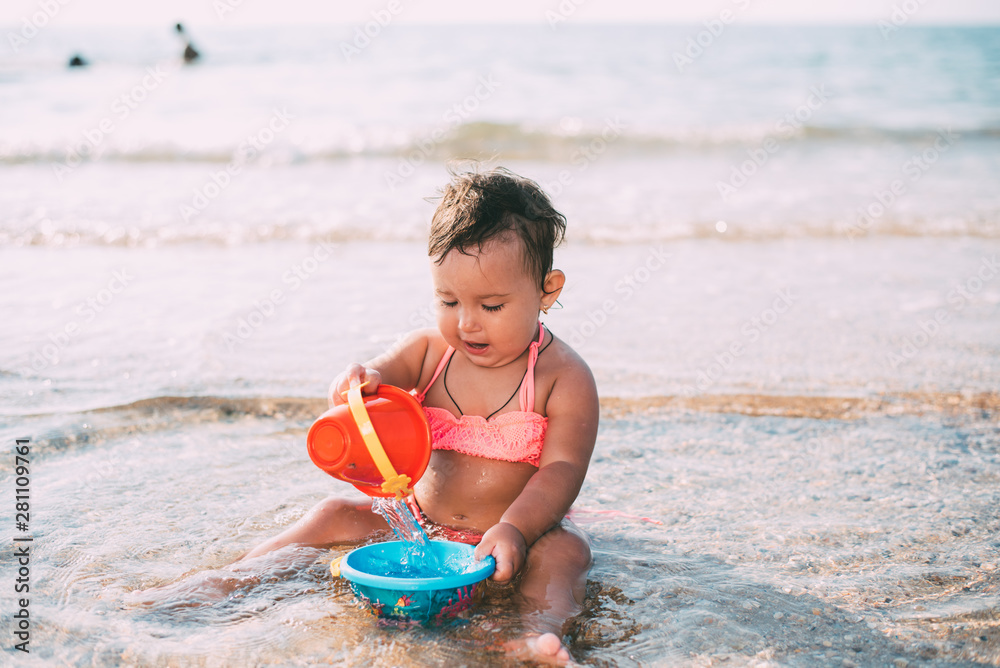 charming girl sitting in the sea pours water collected from the sea charming girl sitting in the sea pours water collected from the sea