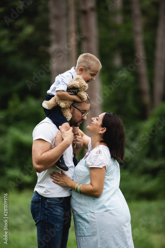 Pregnant young woman with her family in nature © romul014