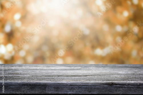 Wooden table and blurred bokeh autumn background.