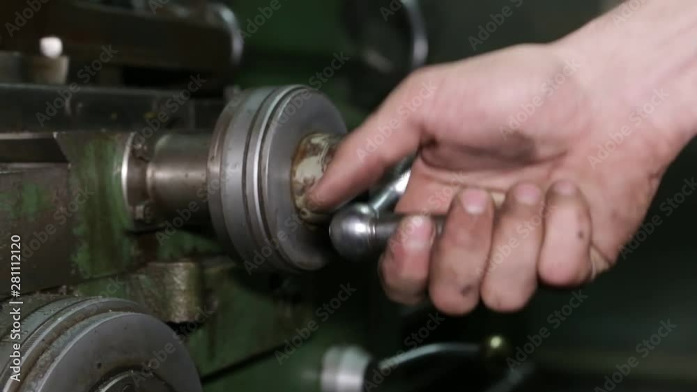 Machine operator operates on old lathe machine.Turning lathe in action. Machine operator operates on old lathe machine.Turning lathe in action.