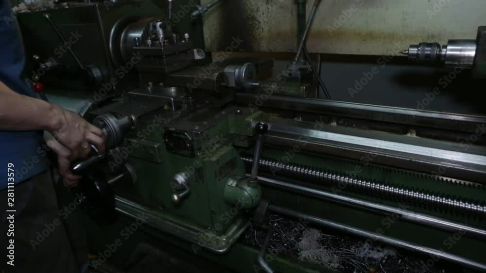 Lathe in action. Old lathe in the lathe shop.The operator of the machine works on an old lathe. Setting up the lathe Lathe in action. Old lathe in the lathe shop.The operator of the machine works on an old lathe. Setting up the lathe