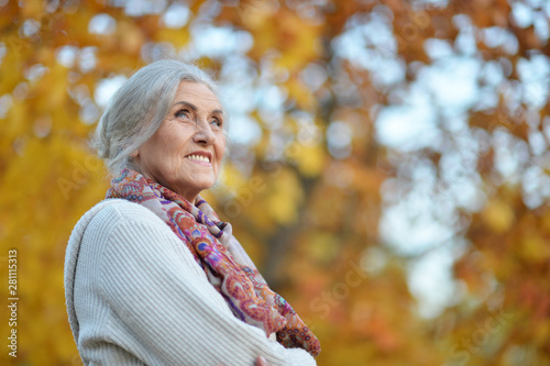 Portrait of happy senior woman in autumn park