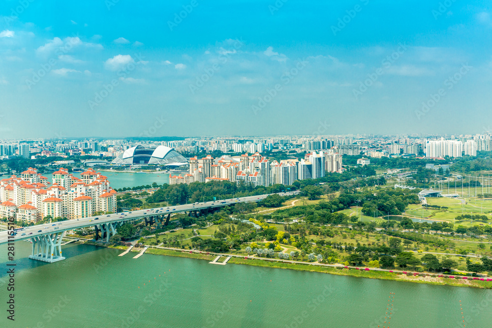 Aerial panoramic view over Singapore with the rainforest meeting the city under a clear blue sky