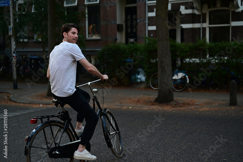 Spontaneous Dutch male student riding his bicycle on the steet where he lives