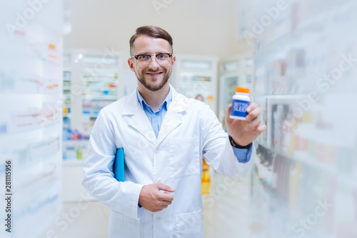 Positive delighted young chemist showing favorite probiotics