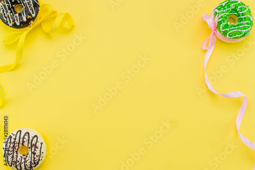 donuts on a yellow background and space for text. Childrens party concept.