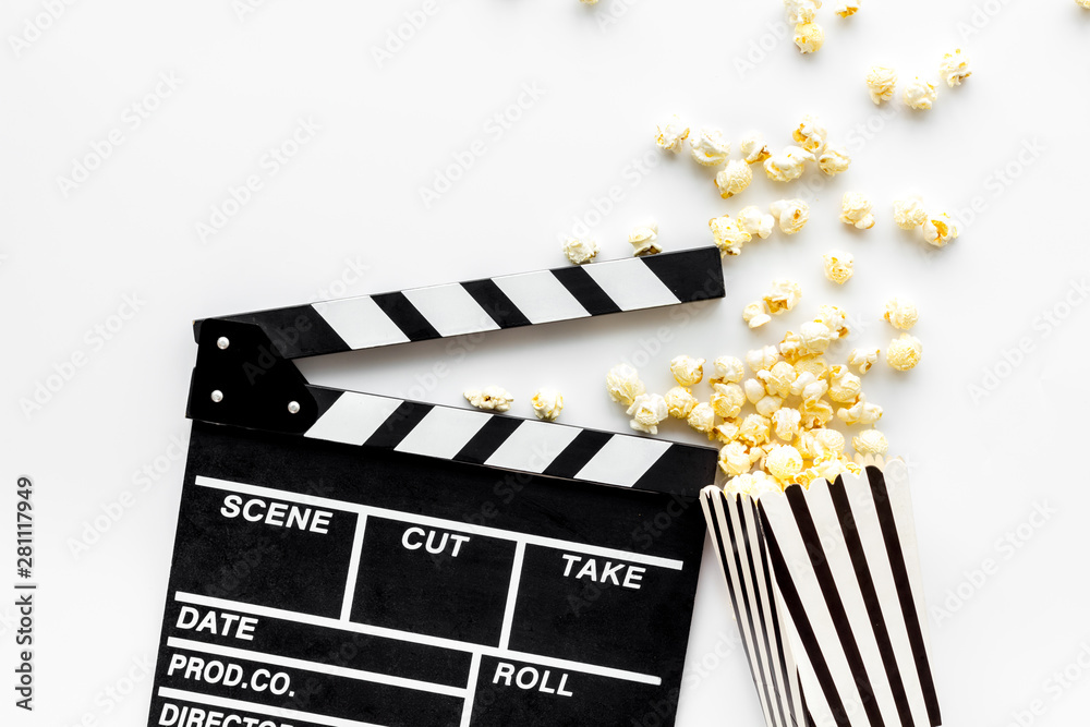 Obraz premium Go to the cinema with popcorn and clapperboard on white background top view mockup