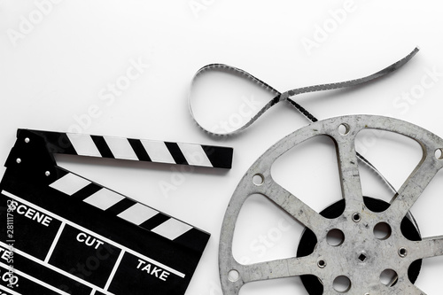 Filmmaker profession with clapperboard and video tape on white background top view