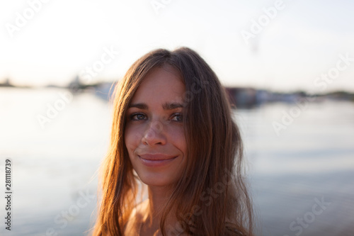 Closeup portrait of effective girl with long hair smiling to camera having fun on the beach,vacation mood