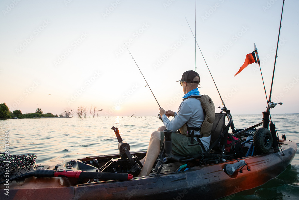 Young Man Kayak Fishing at Sunrise in Canada