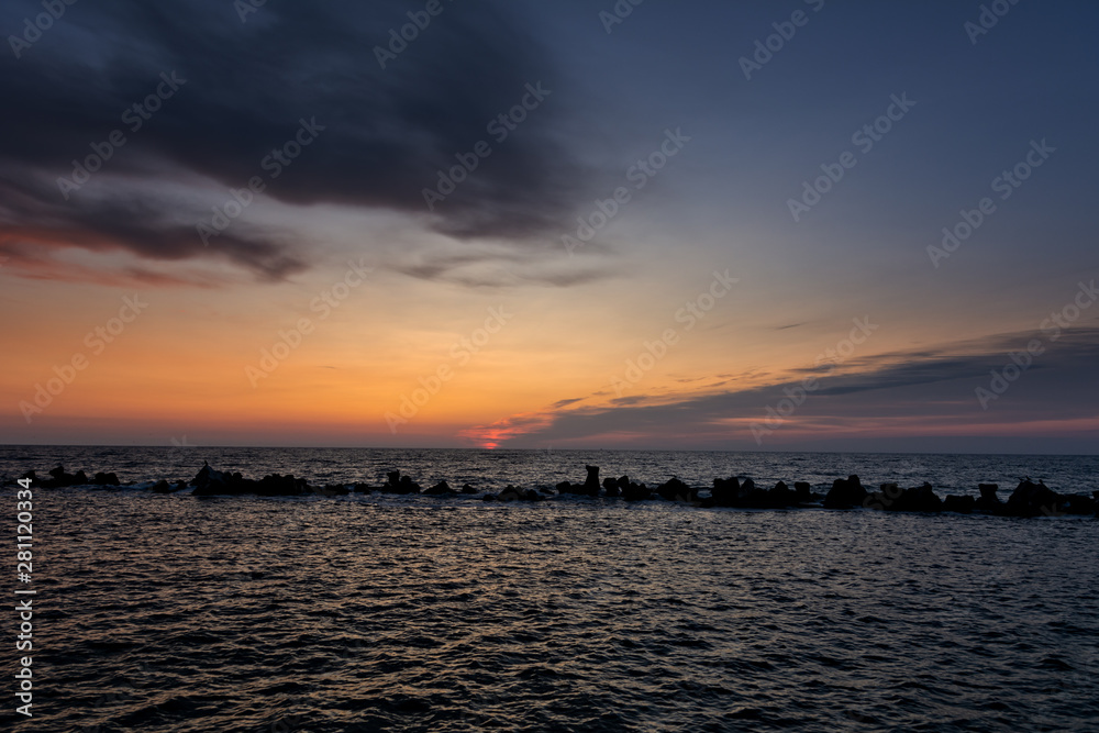Twilight period before sunrise over the calm sea. Summer sea with blue water and purple sky at the sunset