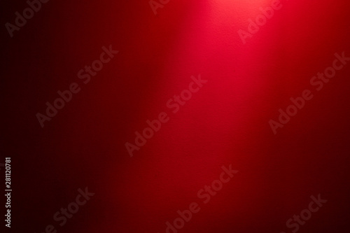 Light red ray of light on a dark red finely textured background