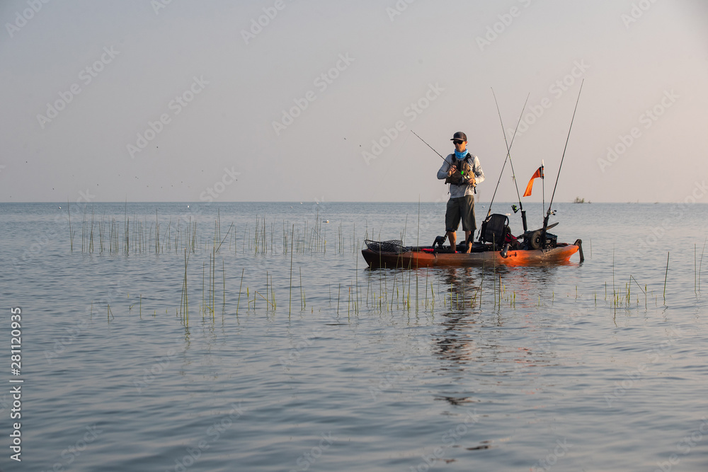 Naklejka premium Young Man Kayak Fishing at Sunrise in Canada