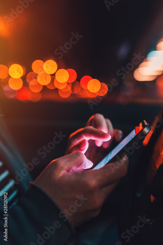 Woman texting on mobile phone in car at night