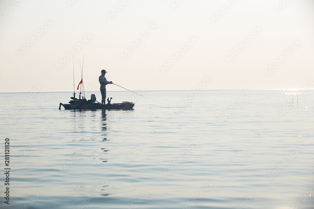 Young Man Kayak Fishing at Sunrise in Canada
