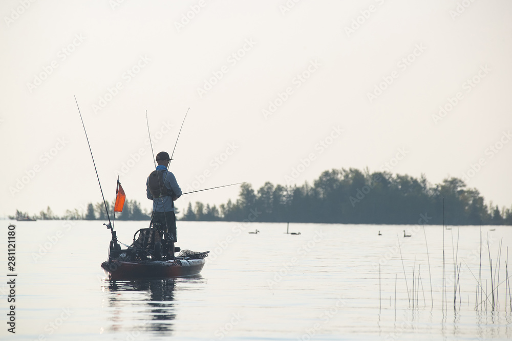 Young Man Kayak Fishing at Sunrise in Canada