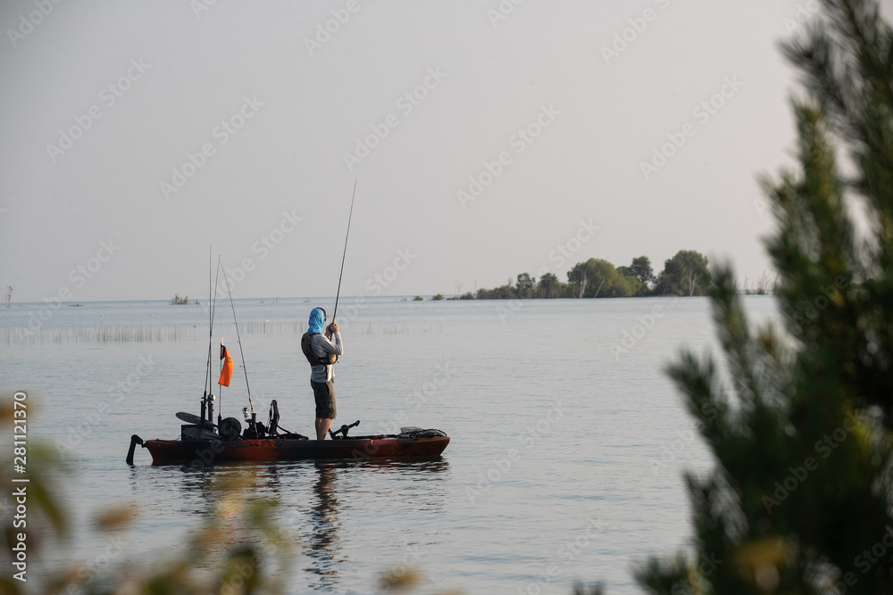 Young Man Kayak Fishing at Sunrise in Canada Young Man Kayak Fishing at Sunrise in Canada