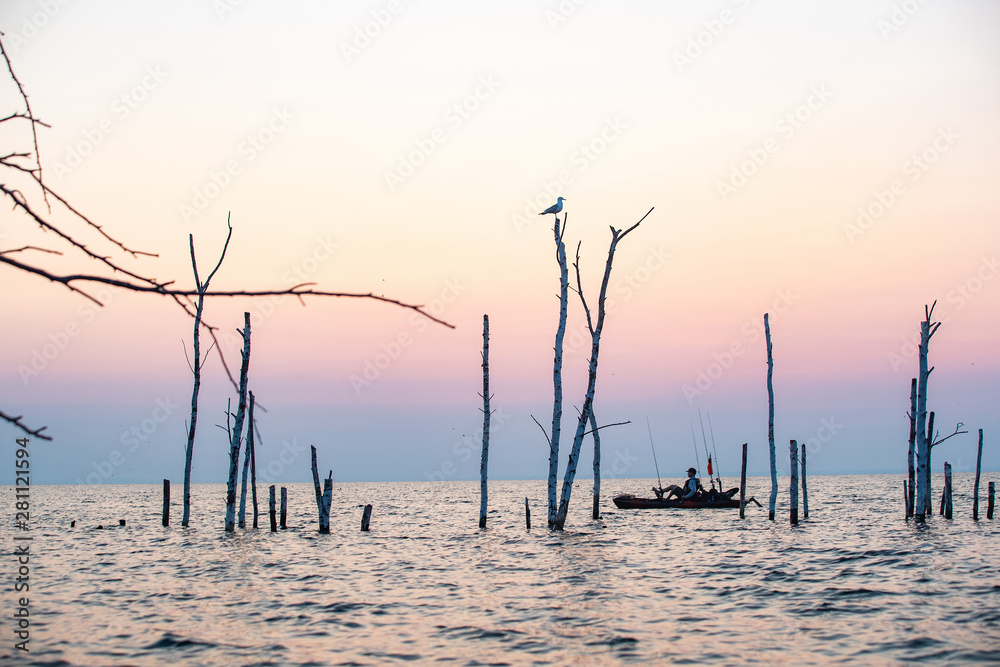 Young Man Kayak Fishing at Sunrise in Canada