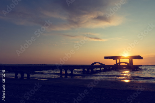 Vintage look of an amazing sunrise over old and abandoned pontoon