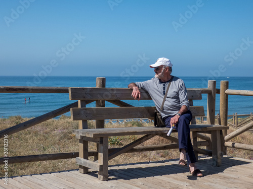 Wallpaper Mural Old man on beach sitting on the  bench looking at  the sea Torontodigital.ca