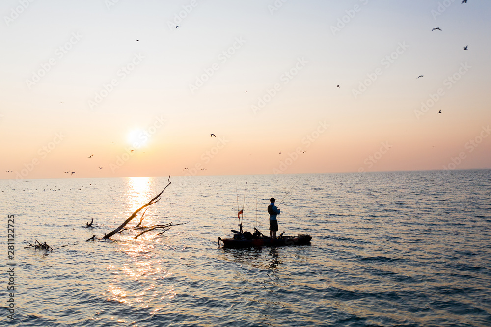 Fototapeta premium Young Man Kayak Fishing at Sunrise in Canada