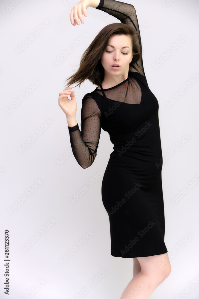 Horizontal Portrait of a pretty slim beautiful fashionable adult girl with beautiful brunette hair in a black dress. It should be in full growth, talking showing different poses and emotions Horizontal Portrait of a pretty slim beautiful fashionable adult girl with beautiful brunette hair in a black dress. It should be in full growth, talking showing different poses and emotions