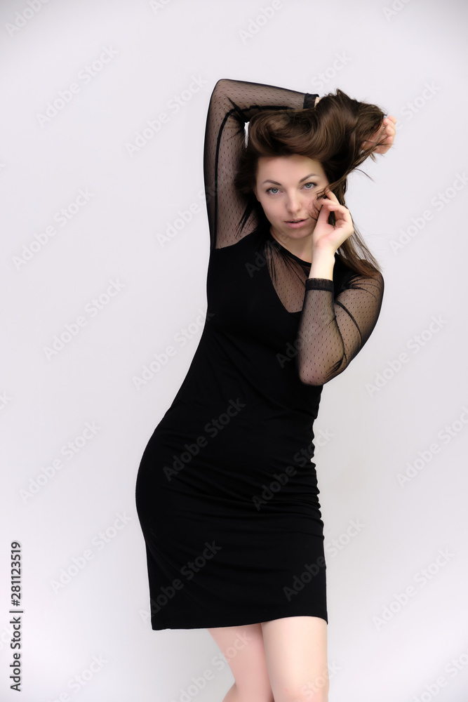 Horizontal Portrait of a pretty slim beautiful fashionable adult girl with beautiful brunette hair in a black dress. It should be in full growth, talking showing different poses and emotions Horizontal Portrait of a pretty slim beautiful fashionable adult girl with beautiful brunette hair in a black dress. It should be in full growth, talking showing different poses and emotions