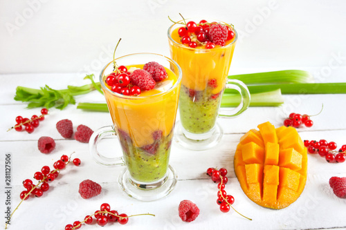 A multi-layered smoothie with mango, kiwi, celery, currants and raspberries