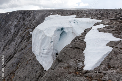 Big snow cap on stones of cliff at summer season, Khibins mountains, Russia photo