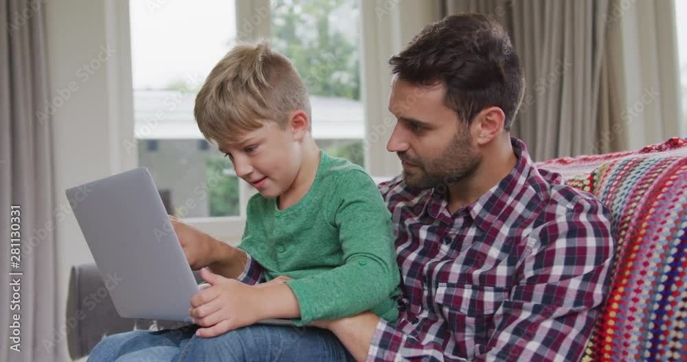 Father and son using laptop in a comfortable home 4k Father and son using laptop in a comfortable home 4k