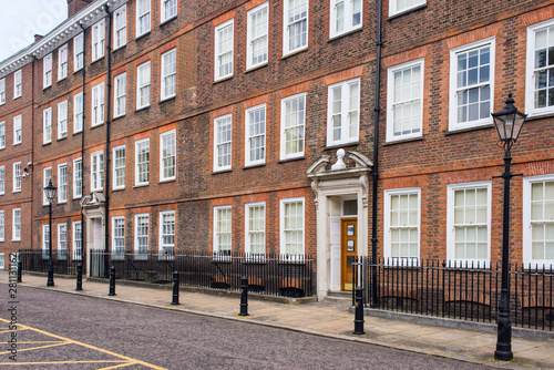 Classic historical apartments Building in Georgian British English style with white windows and red brick wall in central London