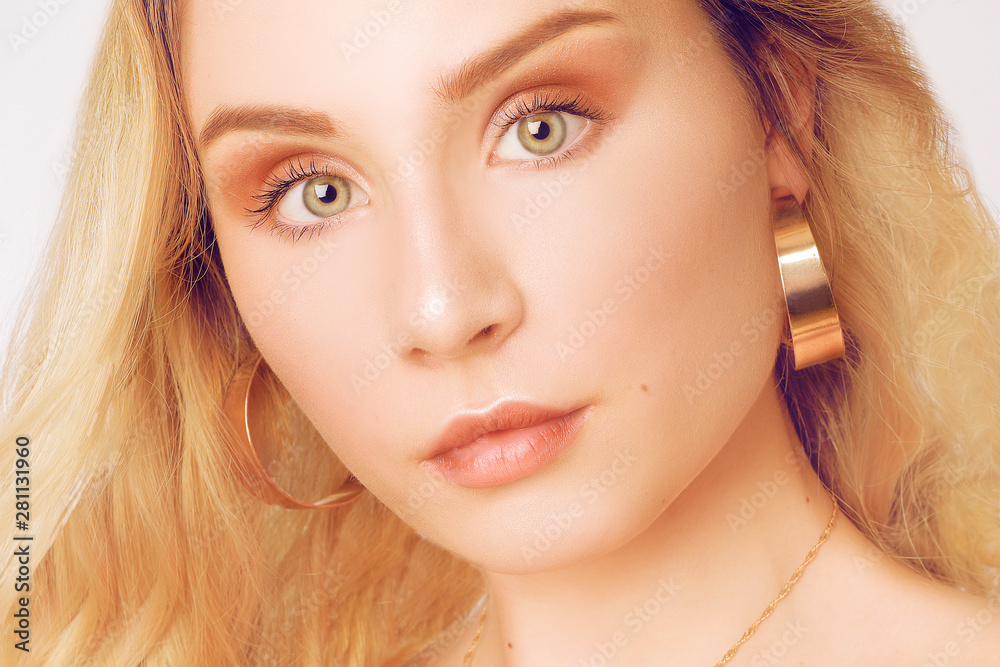 Portrait of a beautiful blonde with long hair. Girl with gold earrings, jewelry. The girl with green eyes. Studio shot. A young girl, with a beautiful neutral make-up. Portrait of a beautiful blonde with long hair. Girl with gold earrings, jewelry. The girl with green eyes. Studio shot. A young girl, with a beautiful neutral make-up.