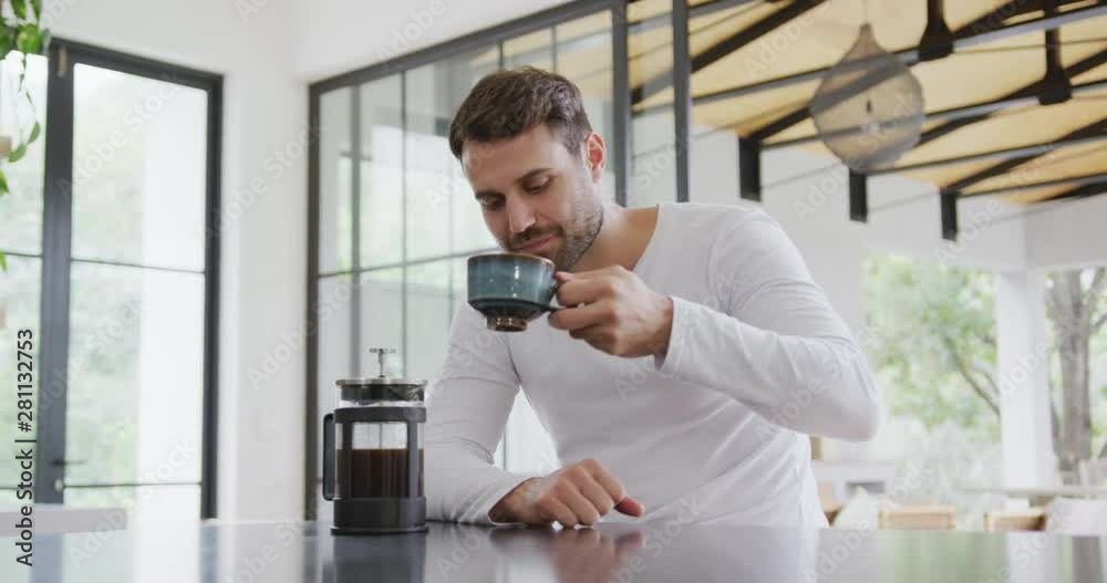 Man drinking coffee at dining table in a comfortable home 4k