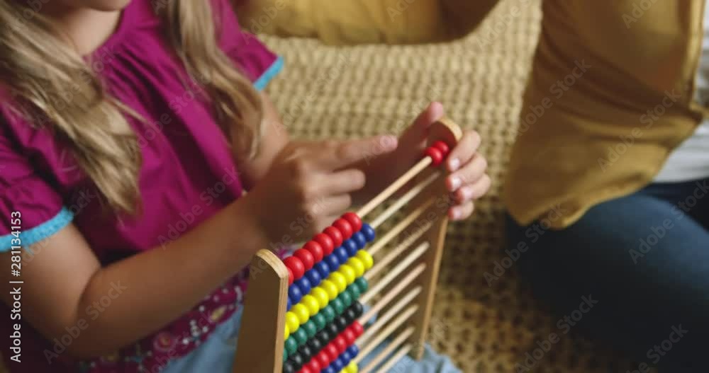 Mother teaching her daughter mathematics on abacus at home 4k