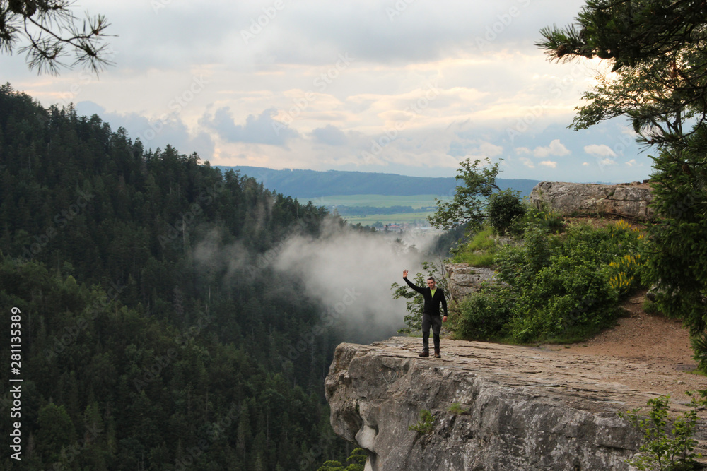 A man standing on a ledge just above the abyss