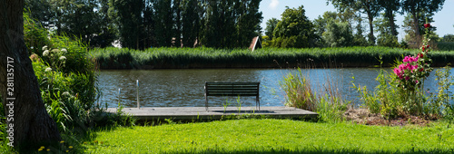 jetty with bench, along called Alkmaar Kolhorn. In place called  Broek op Langedijk, The Netherlands photo