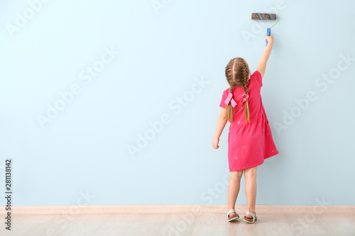 Little girl painting wall i...