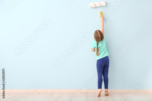 Little girl painting wall i...