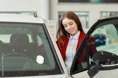 Woman choosing new car in s...