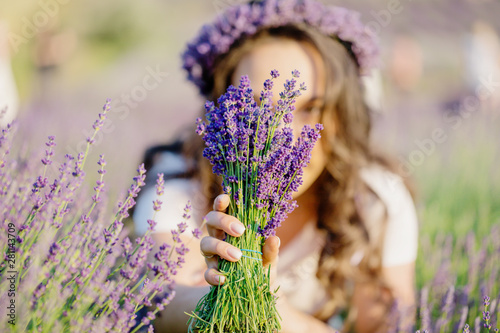 Beautiful girl holding purple violet lavender bouquet on the lavender field