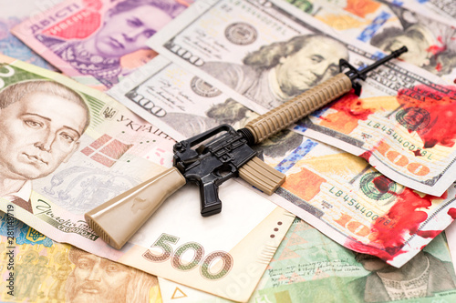 bloody hundred dollars and ukrainian hryvnia and american m16 assault rifle armed conflict support concept photo