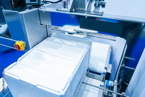 Automatic packing strapping tapes machine. Packing foam by the stretching. Product packaging in polyfoam and contraction of the ribbons. Packaging. Tie ribbons to the goods. Industrial equipment.