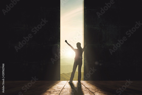 Business woman rise hand up against concrete wall with the way out to natural skyline outdoor view. Business start up and success concept.