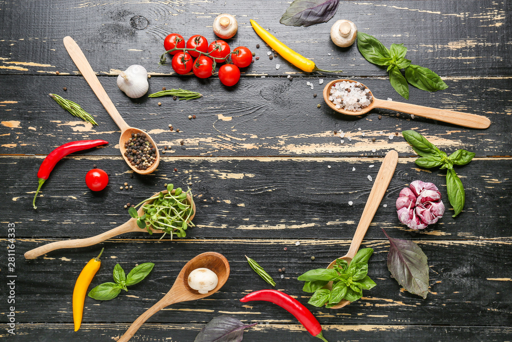 Different fresh herbs and spices on dark wooden background