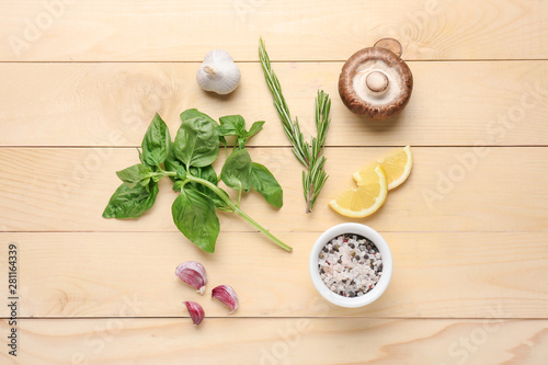 Different fresh herbs and spices on wooden background
