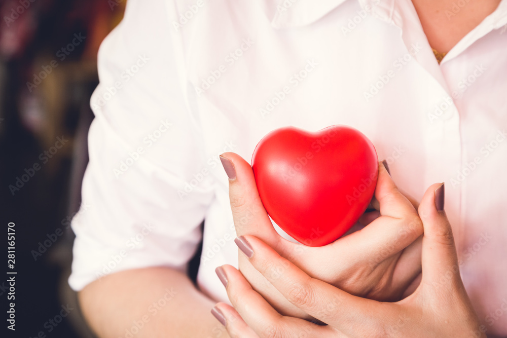 woman hold red heart and wearing white shirt woman hold red heart and wearing white shirt