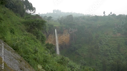 Sipi falls falling into a lush jungle valley while in foggy weather in Africa. photo