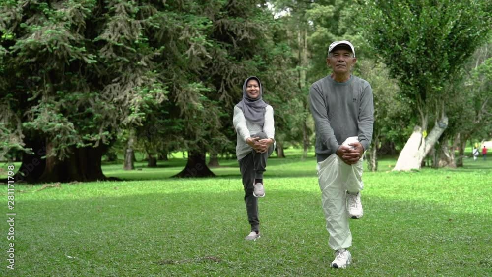 two senior man and woman doing some stretching in nature park together. old people healthcare by doing sport two senior man and woman doing some stretching in nature park together. old people healthcare by doing sport