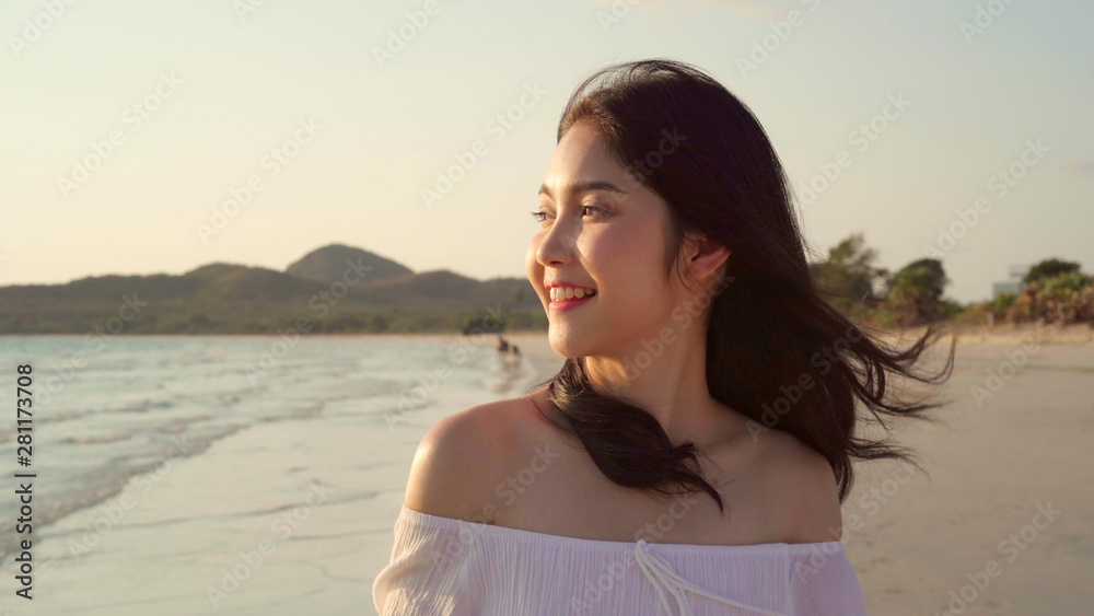 Young Asian woman walking on beach. Beautiful female happy relax walking on beach near sea when sunset in evening. Lifestyle women travel on beach concept. Young Asian woman walking on beach. Beautiful female happy relax walking on beach near sea when sunset in evening. Lifestyle women travel on beach concept.